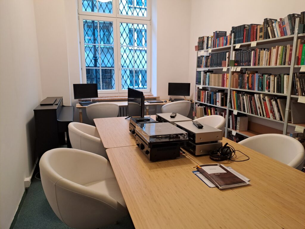 Reading Room of the National Institute of Music and Dance, book shelves, computer with DVD and VHS recorder, arm chairs.